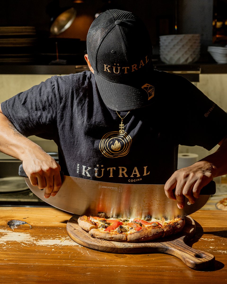 Equipo de KÜTRAL cortando una pizza en la cocina